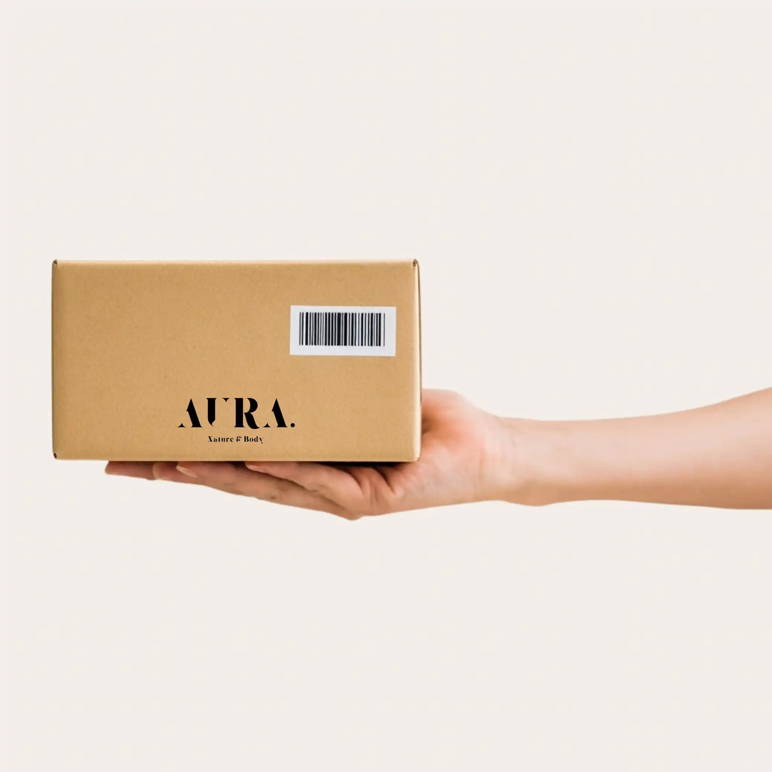 Eine ausgestreckte Hand mit einem Paket von Aura - Nature & Body